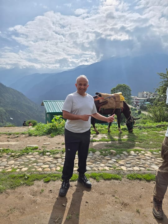 Dr. Harshawardhan Godbole on a mountain path with a pack horse