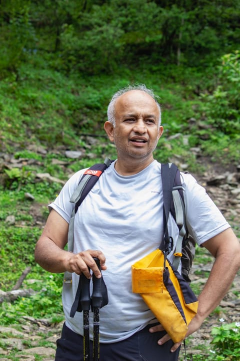 Dr. Harshawardhan Godbole on a forest trail with trekking poles
